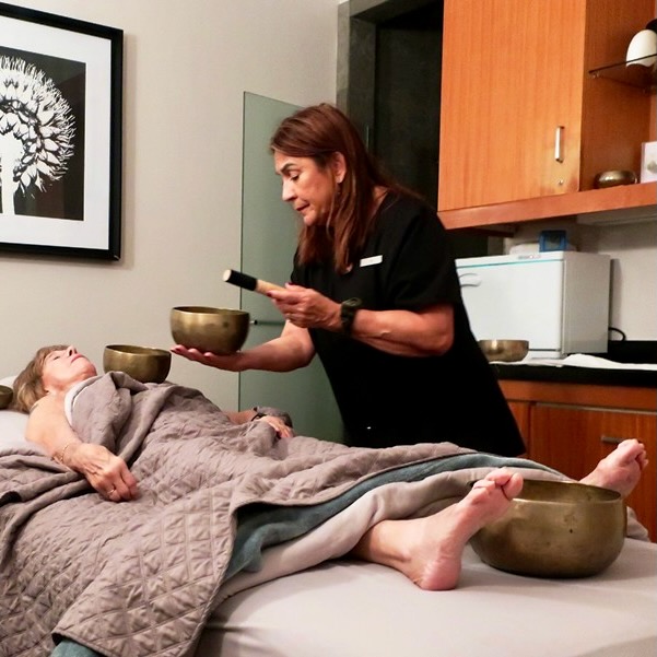 Reiki Master playing Tibetan bowls and chanting